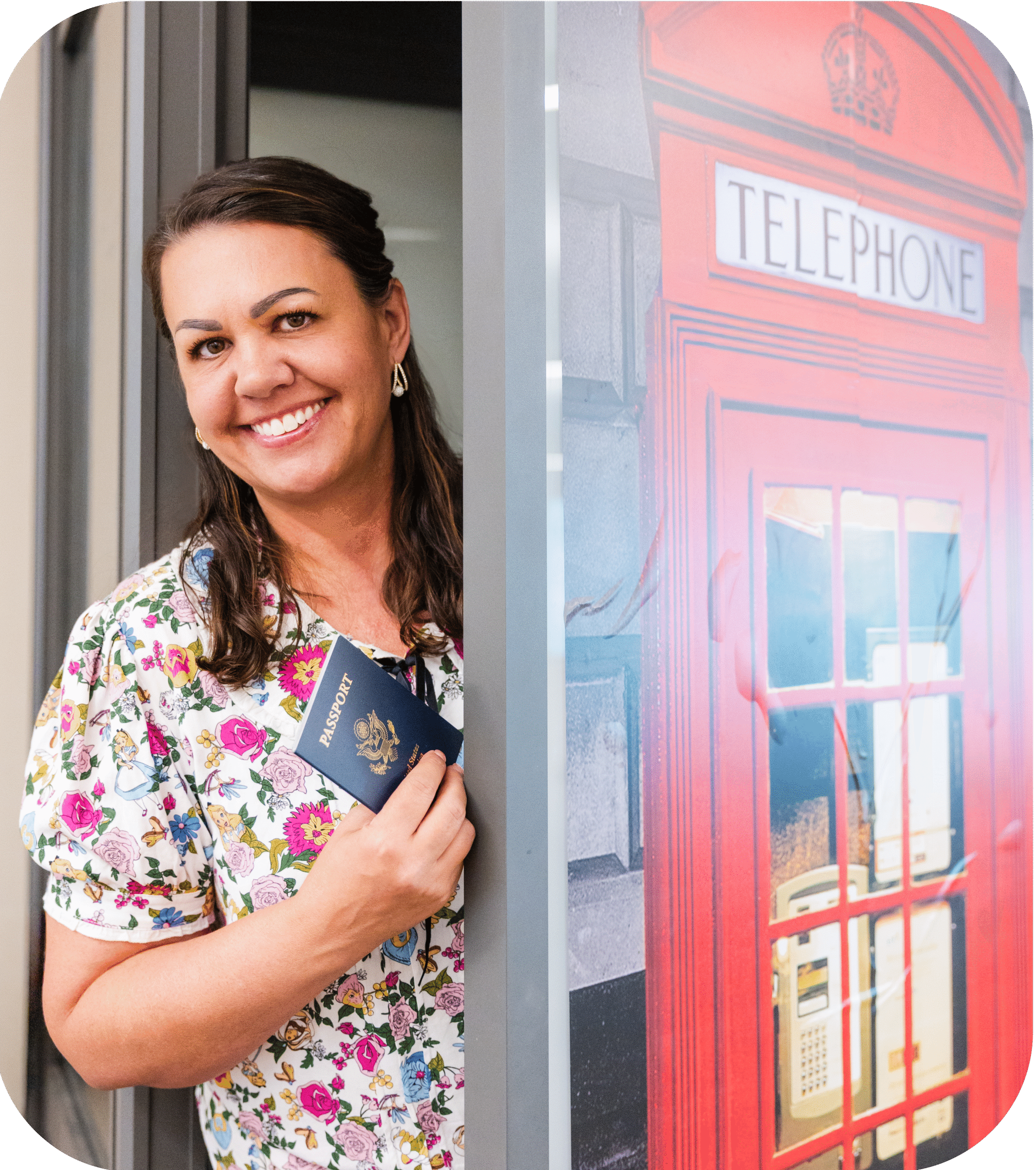 Kena Peterson, owner of Bright Ideas Website Design, smiling beside a red telephone booth with a passport in hand